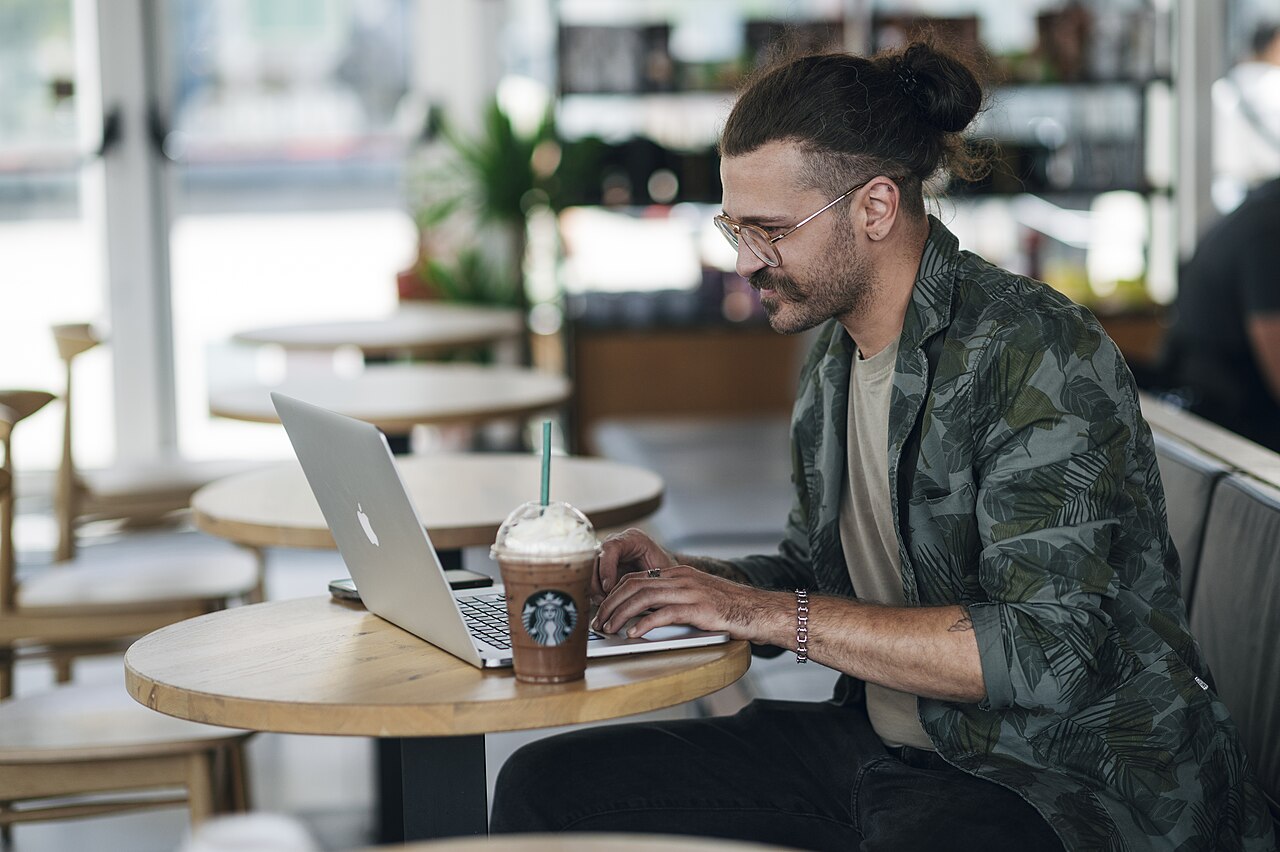 A man working on a laptop in a cafe