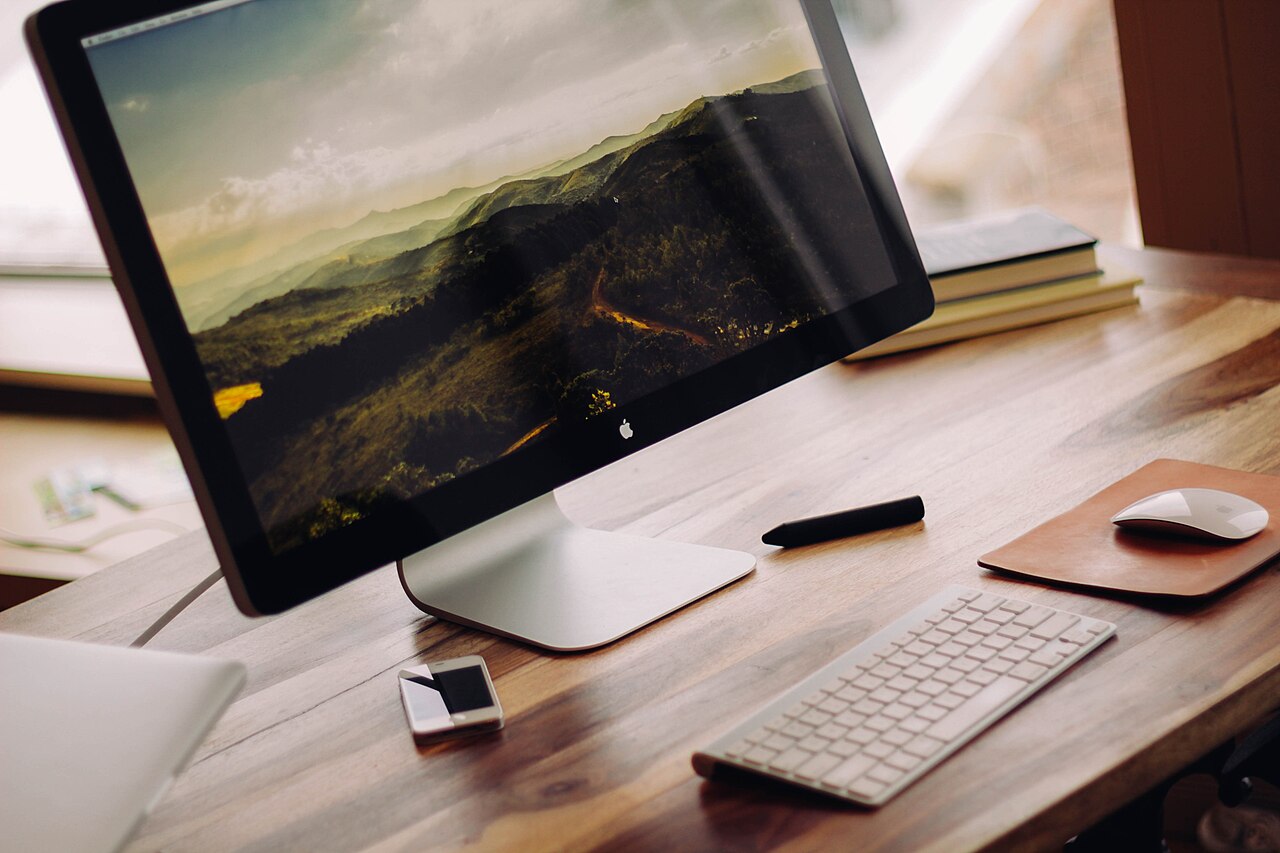 A monitor showing a mountain landscape wallpaper