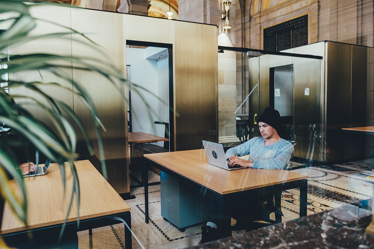 Man working on a laptop in a bright coworking space