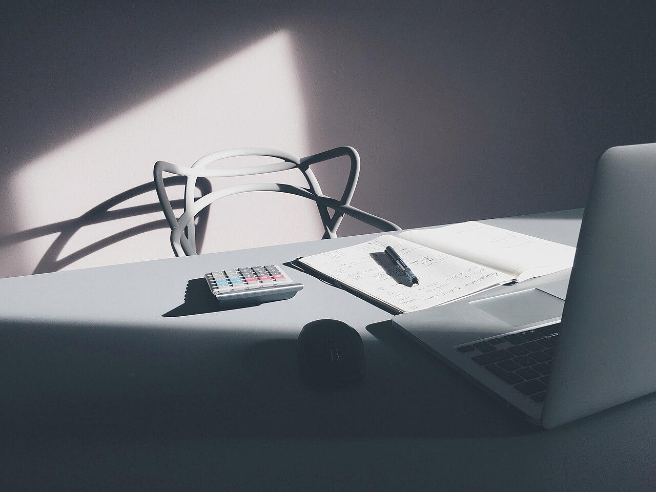 A desk with a laptop and notebook
