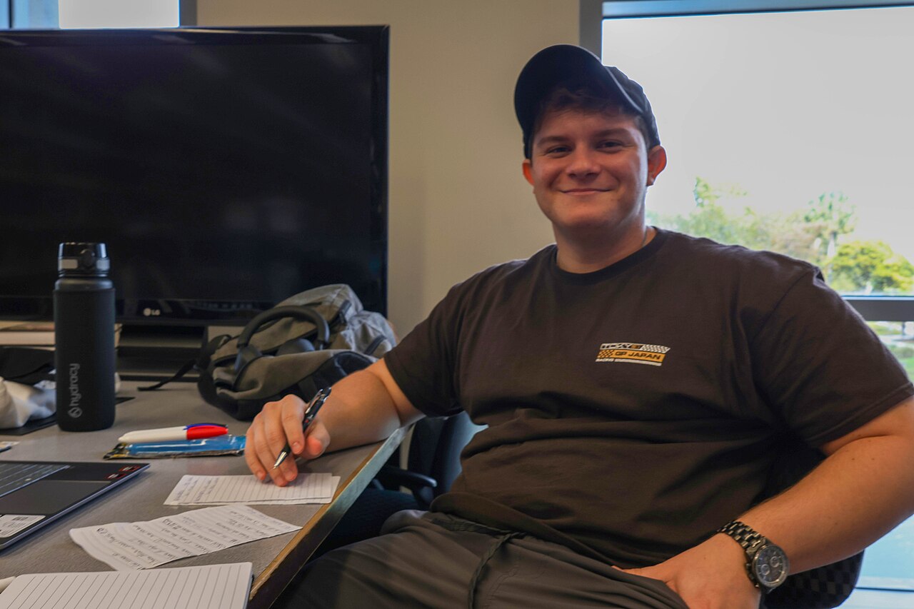 A young man sitting at a desk with notes