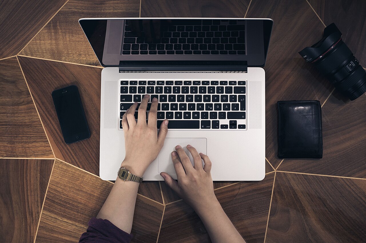 A pair of hands typing on a laptop keyboard