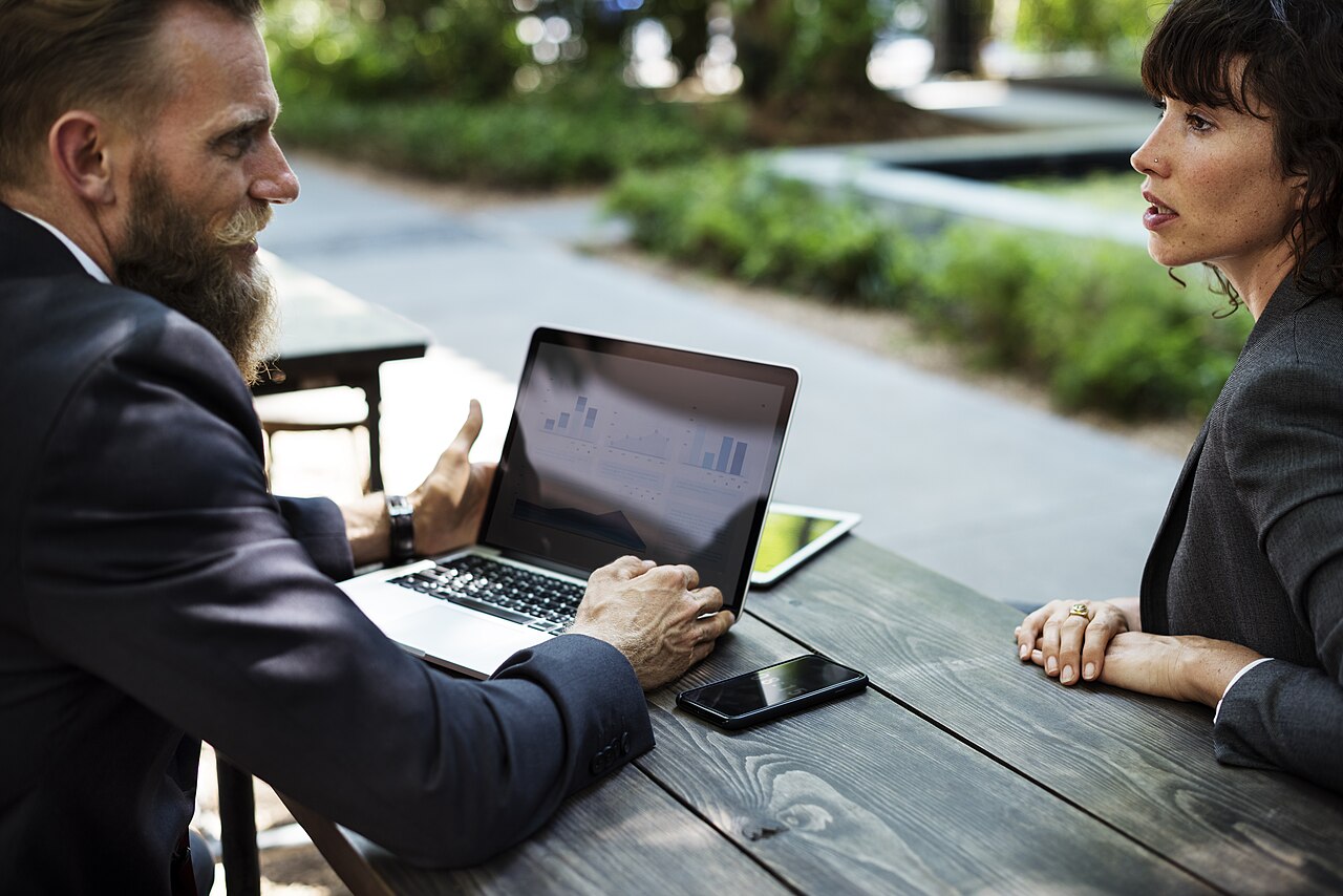 Two people discussing a business plan at a table