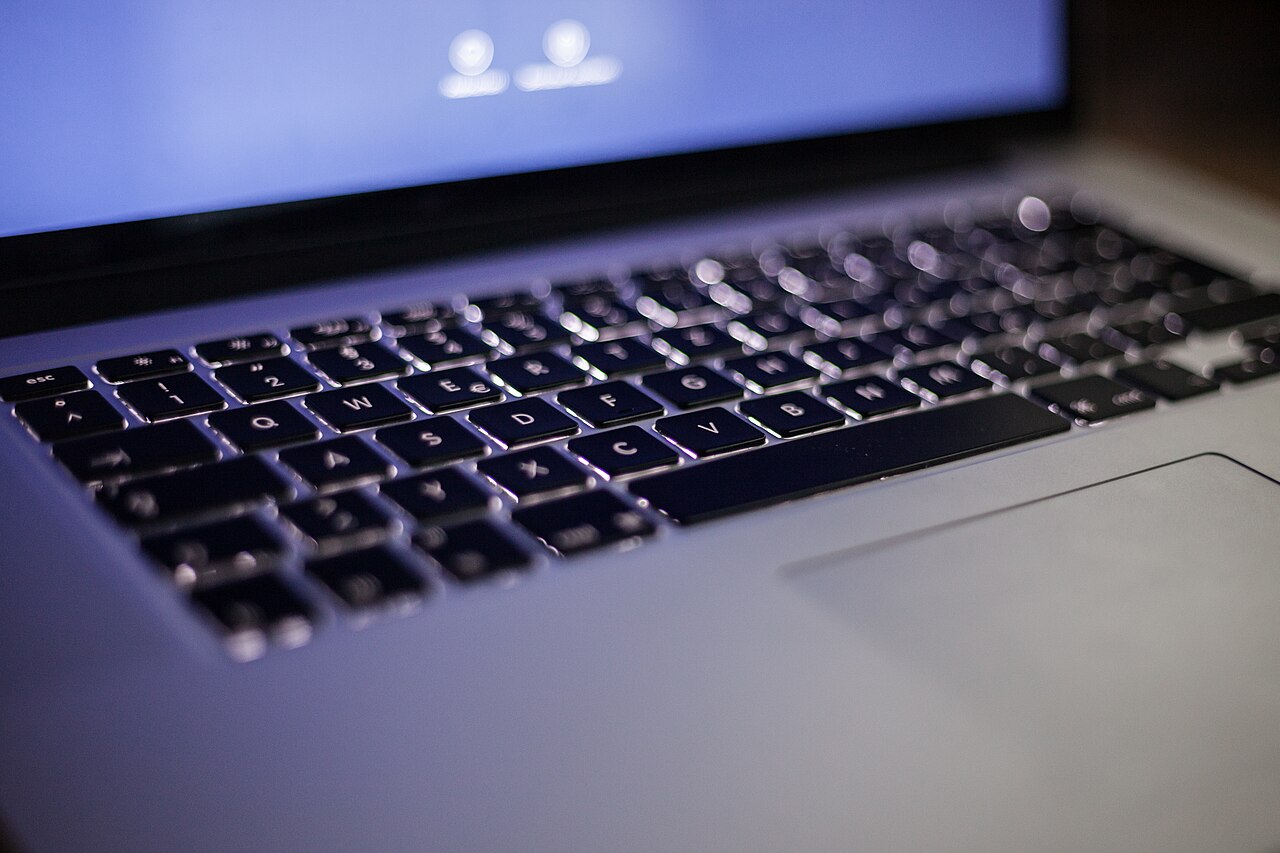 A backlit laptop keyboard in a dark room