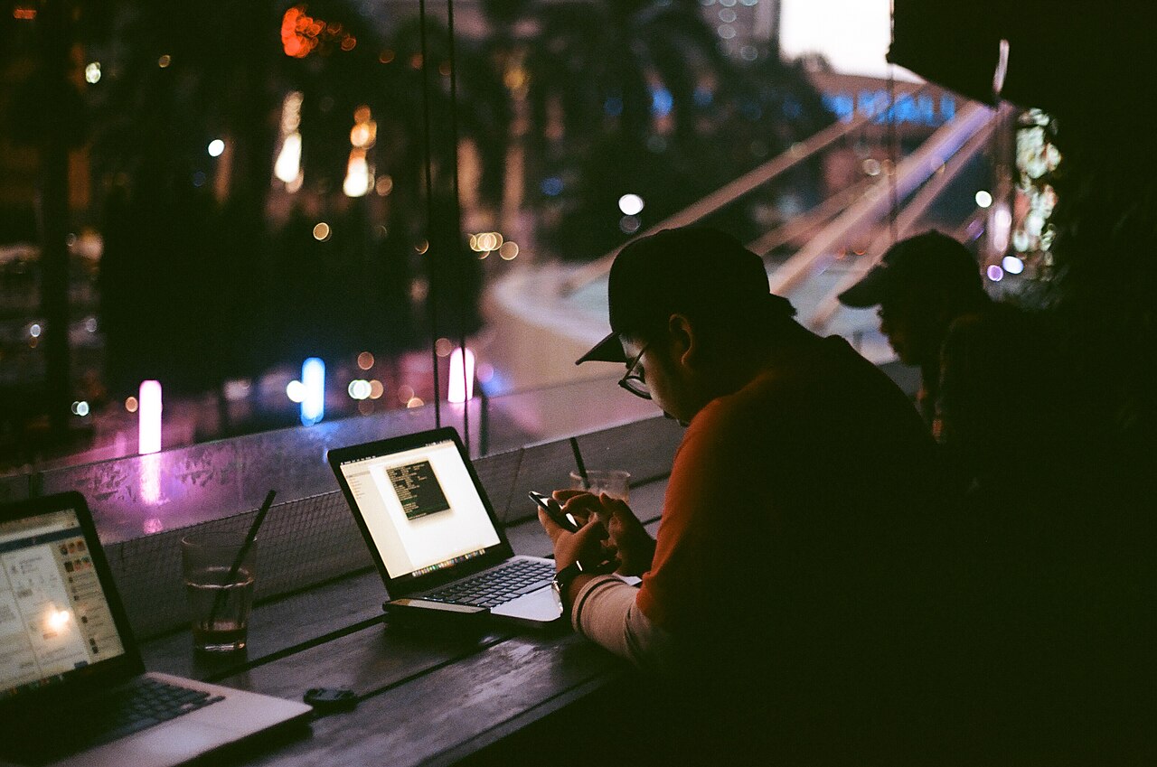 A person working late at a laptop in a dimly lit room