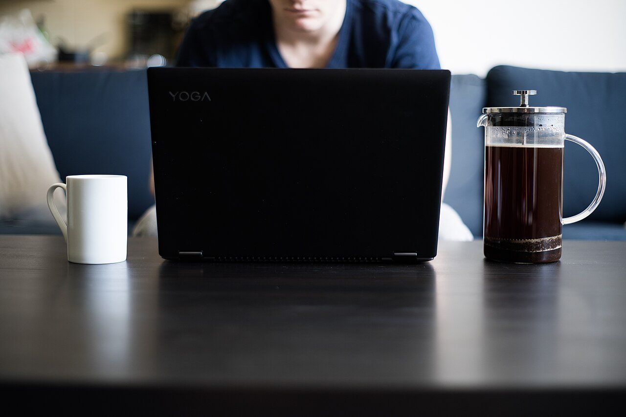 A laptop and a coffee press on a table