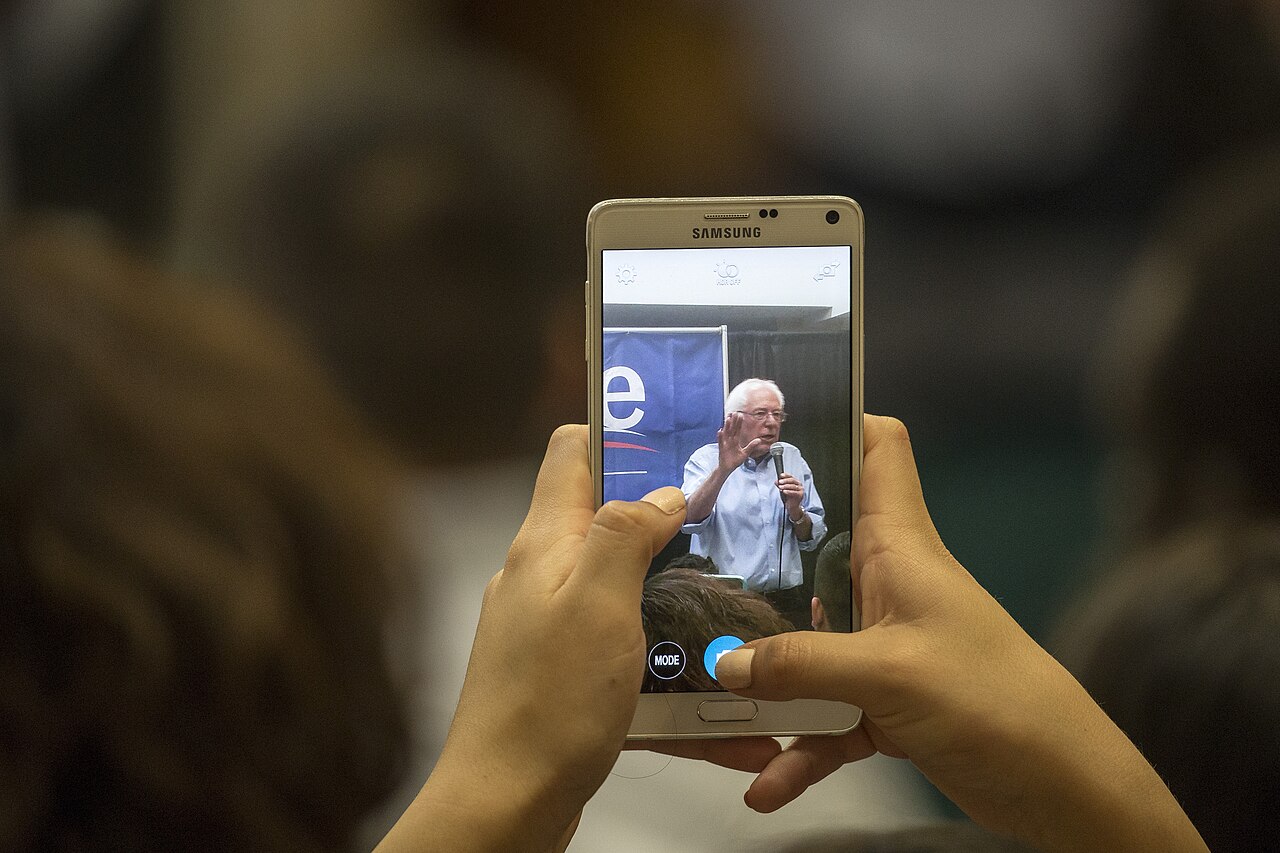 Hands holding a smartphone to record an event