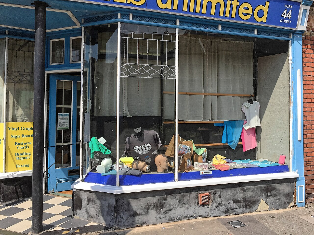 The exterior of a small blue storefront with large windows