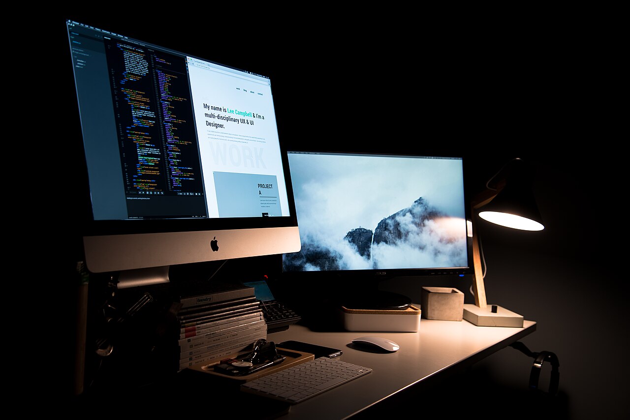 Desktop computer setup with dual monitors in a dark room