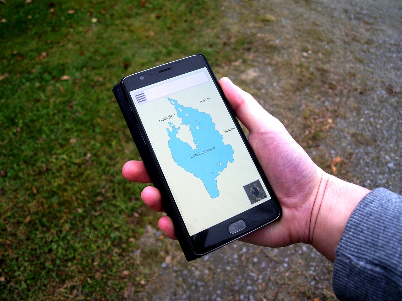 A hand holding a smartphone showing a map application