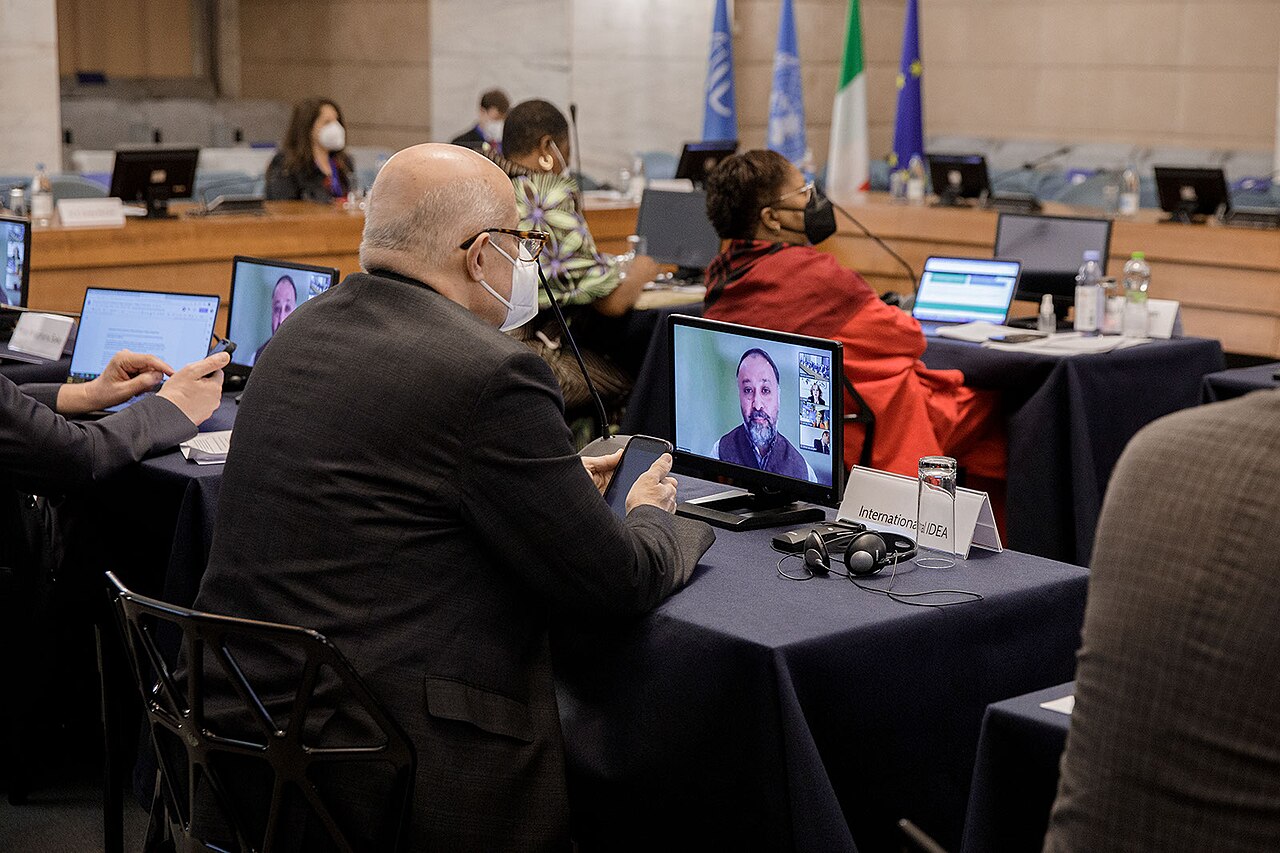 People in a meeting room using laptops and video conferencing