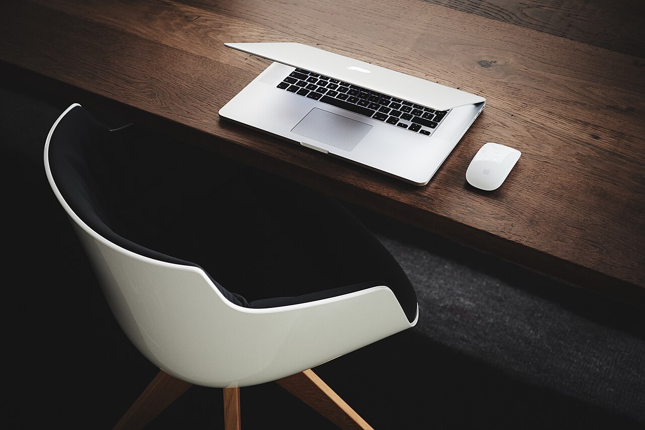 Minimalist office desk with a laptop, mouse and chair